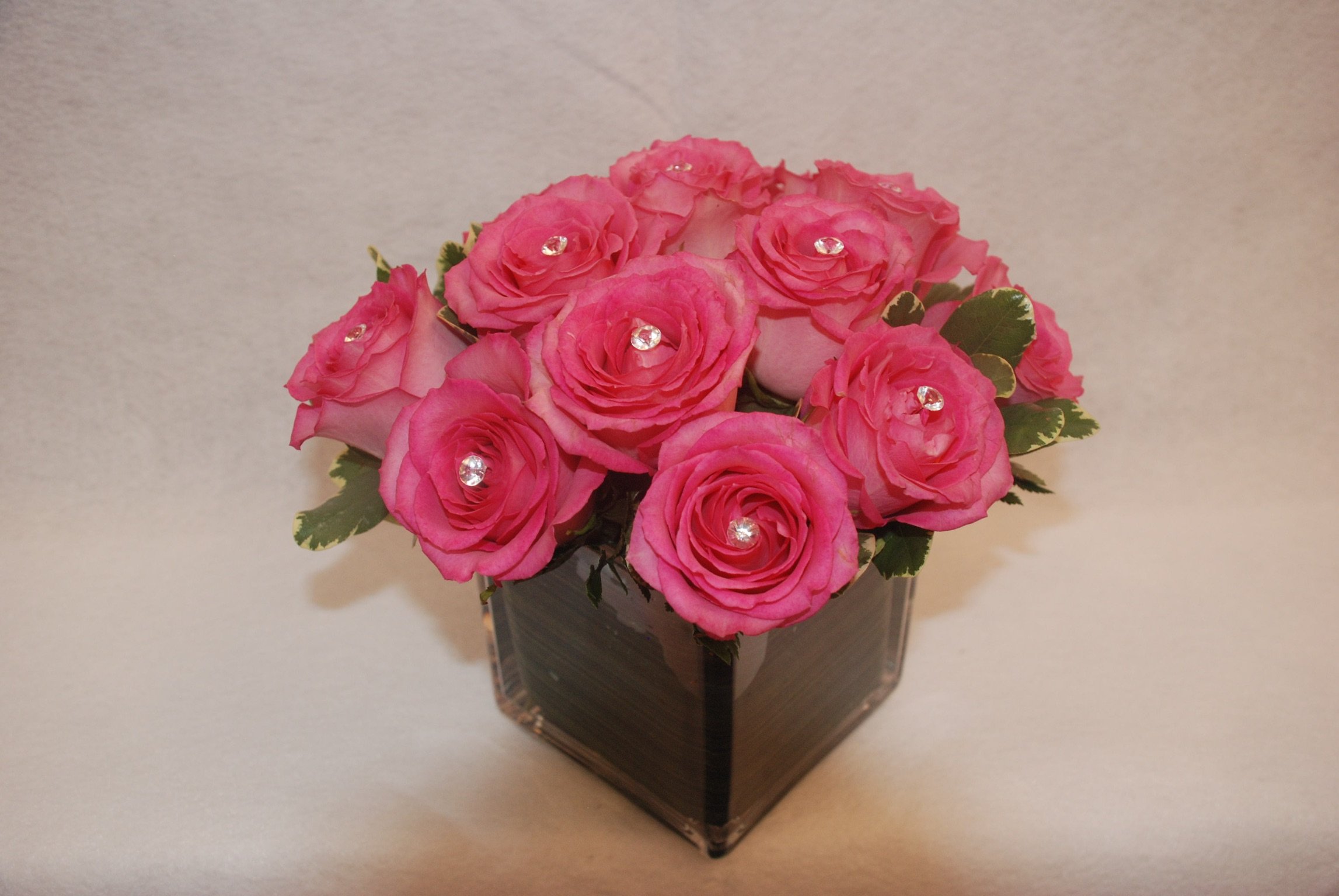 Pink roses with crystal accents in a modern cube vase